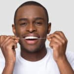 man flossing his teeth